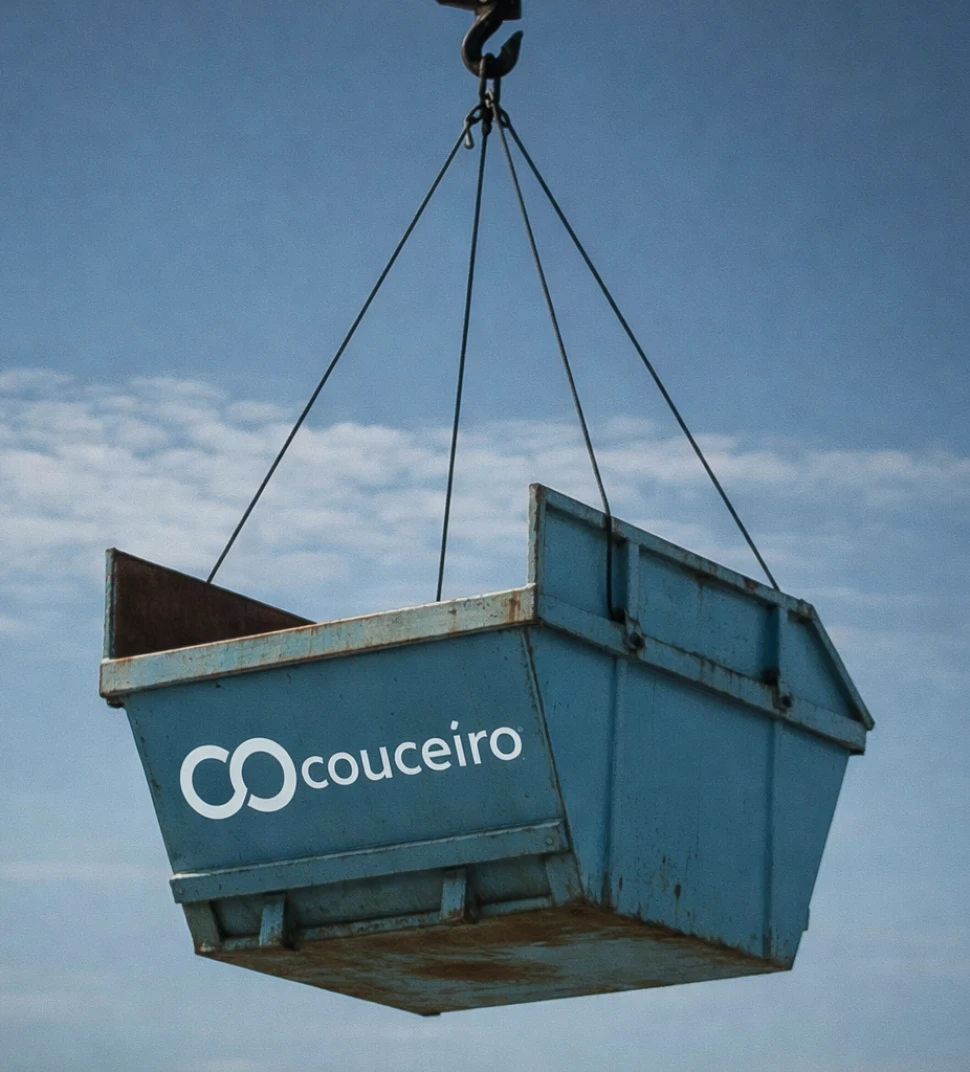 Contenedor de Grupo Couceiro suspendido de una grúa contra el cielo